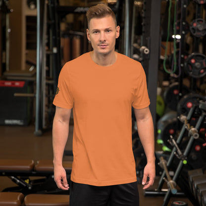 Unisex t-shirt Shroomverse Compass in orange worn by a man in a fitness gym setting.